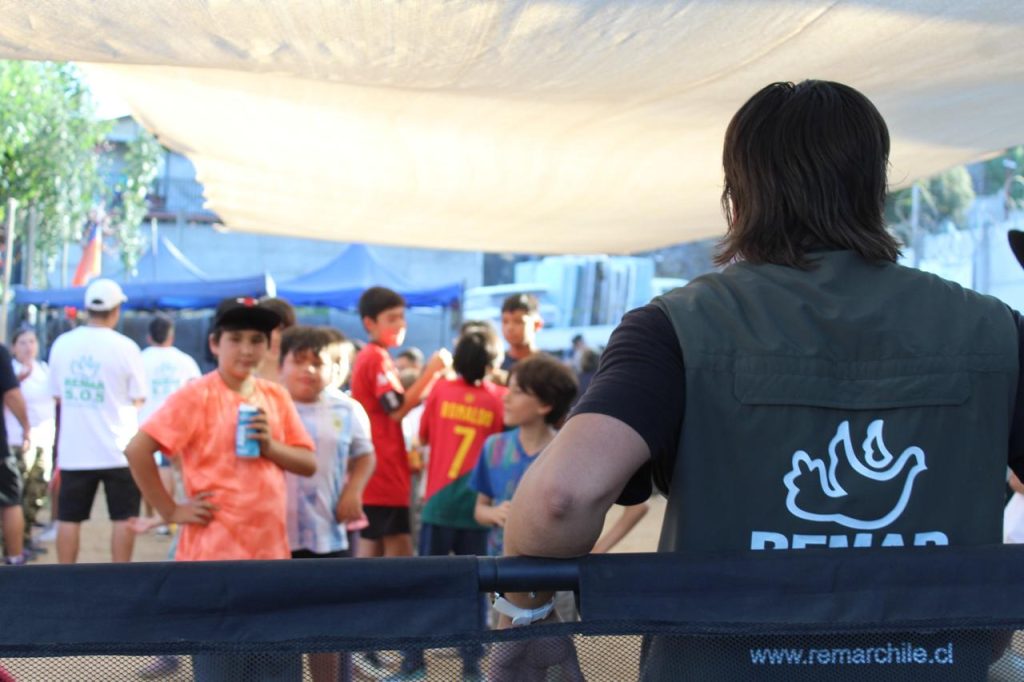 Voluntario de Remar Chile junto a niños en una actividad comunitaria